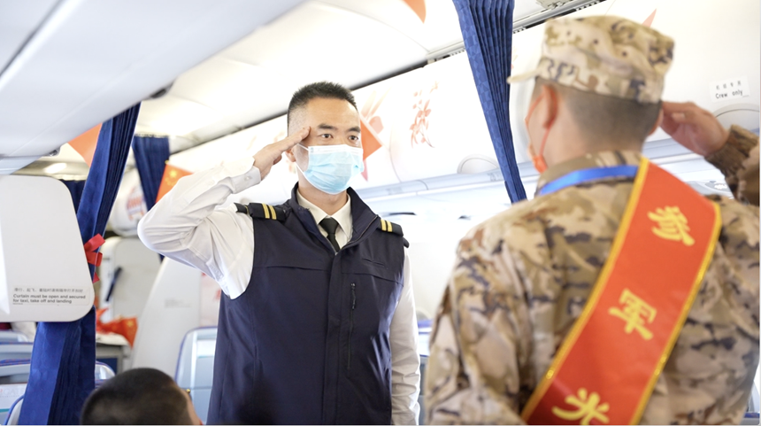 曾在部隊(duì)服役的航空安全員與新入伍士兵互敬軍禮。南航供圖