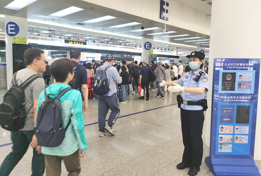 皇崗邊檢站民警在福田口岸出境大廳引導旅客有序快速通關。黃俊生攝